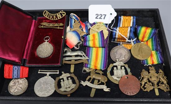 A group of assorted medals and cap badges